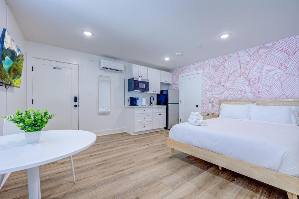 加尔维斯敦Pink Flamingo Studio Apartment的卧室配有白色的床和桌子