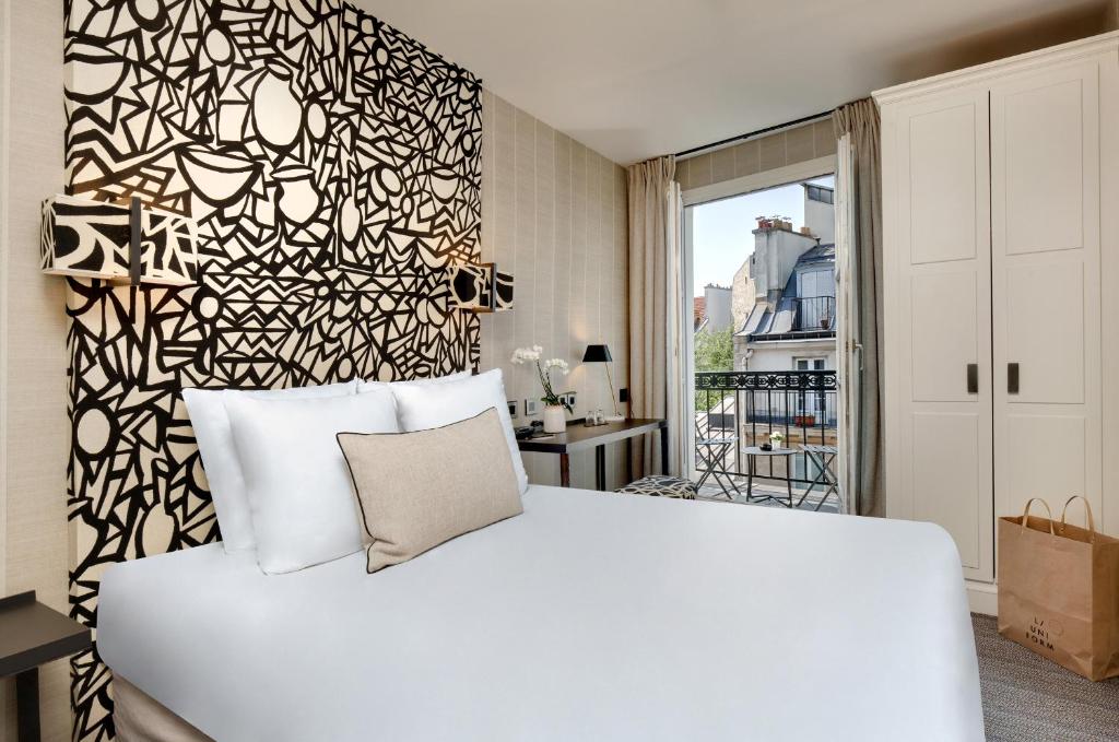 巴黎乐瑟纳酒店的卧室配有白色的床和黑白墙