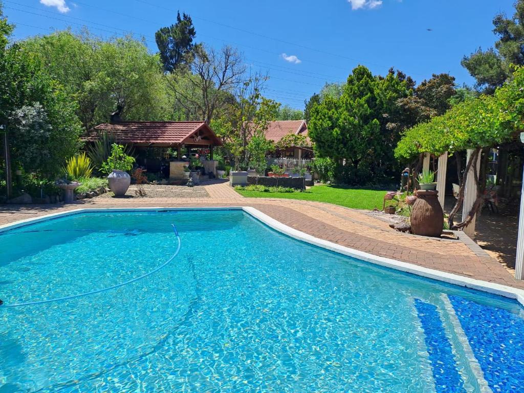 布隆方丹Gabbys Cottage Guesthouse的一座大蓝色游泳池,位于房子前