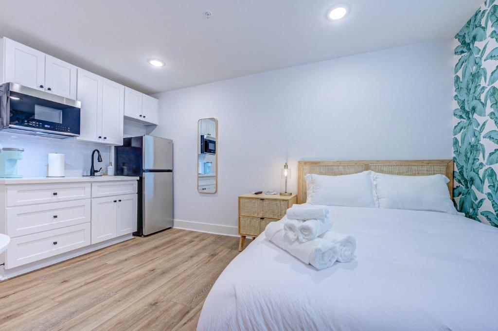 加尔维斯敦Caribbean Sea Studio Apartment的一间带白色床的卧室和一间厨房