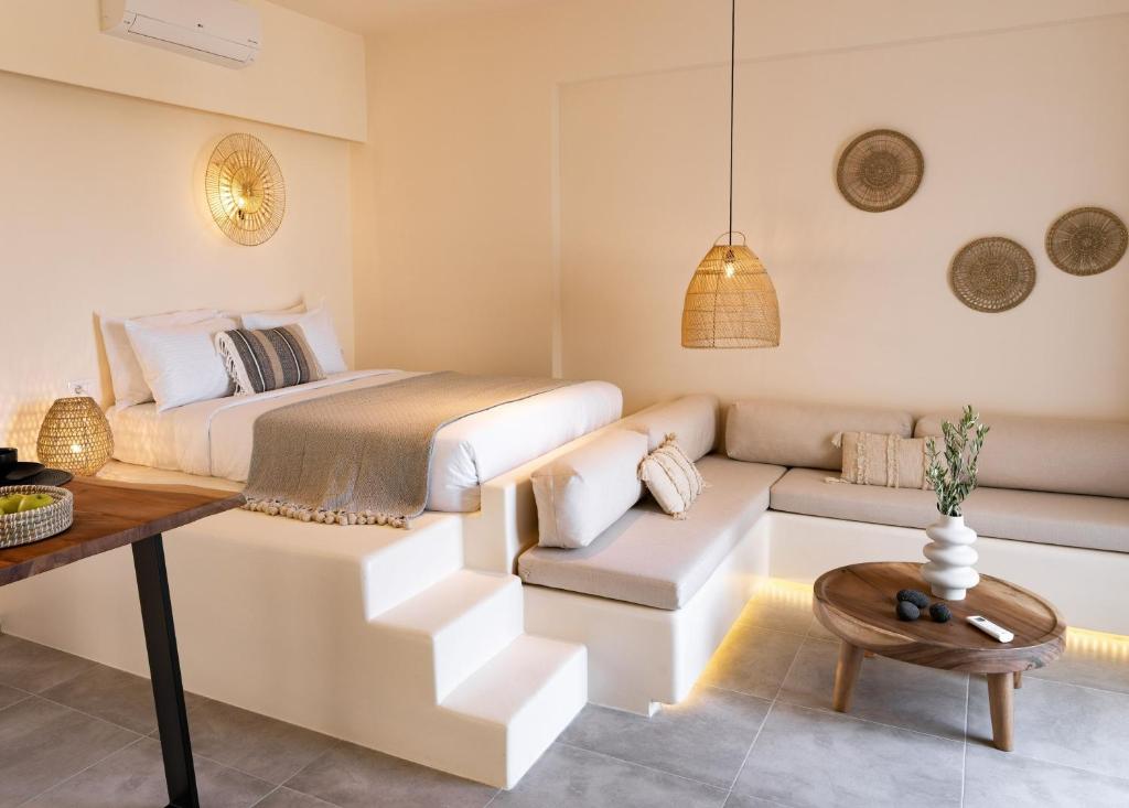 皮尔戈斯Maeva Suites Santorini的一间卧室配有一张特大号床和一张沙发