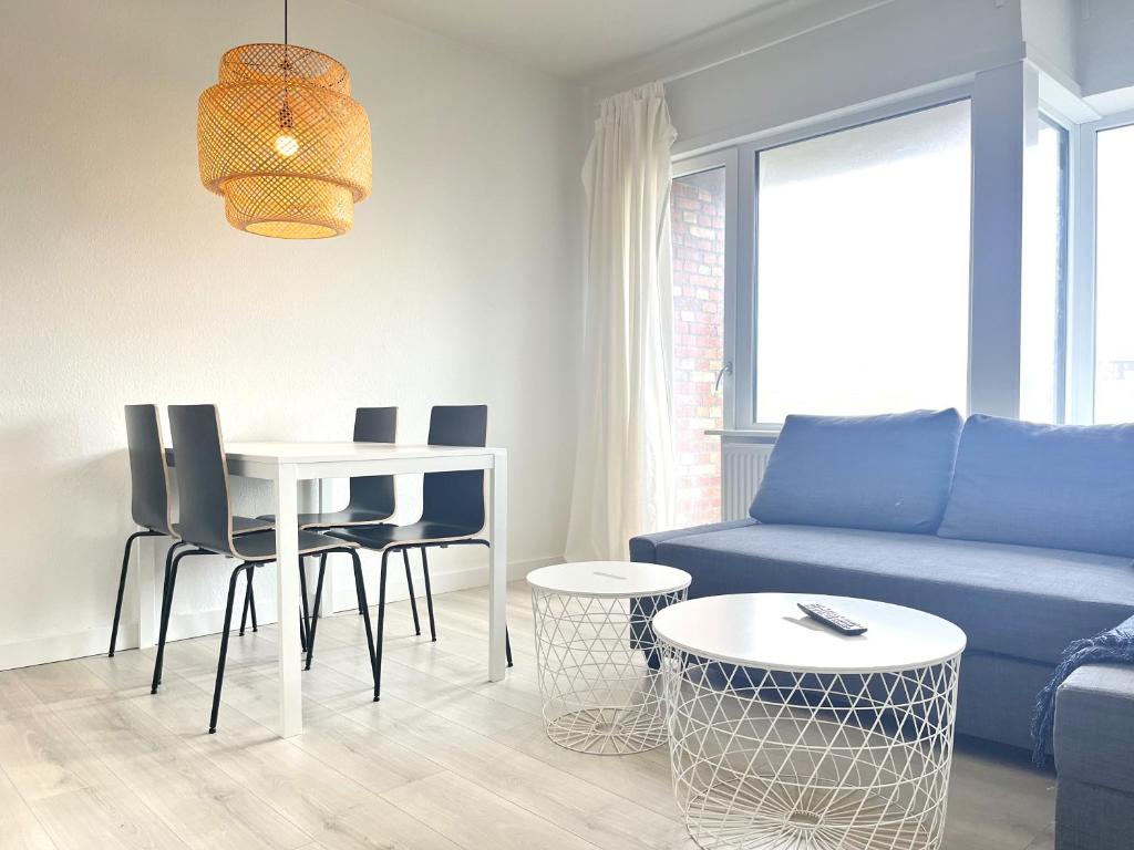 科灵Newly Renovated Apartment With 1 Bedroom In Kolding的客厅配有蓝色的沙发、桌子和椅子