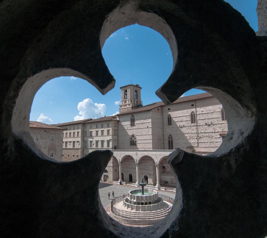 佩鲁贾Umbrian Concierge - Cozy Loft Vannucci的从一座带喷泉的建筑的雕塑中看到