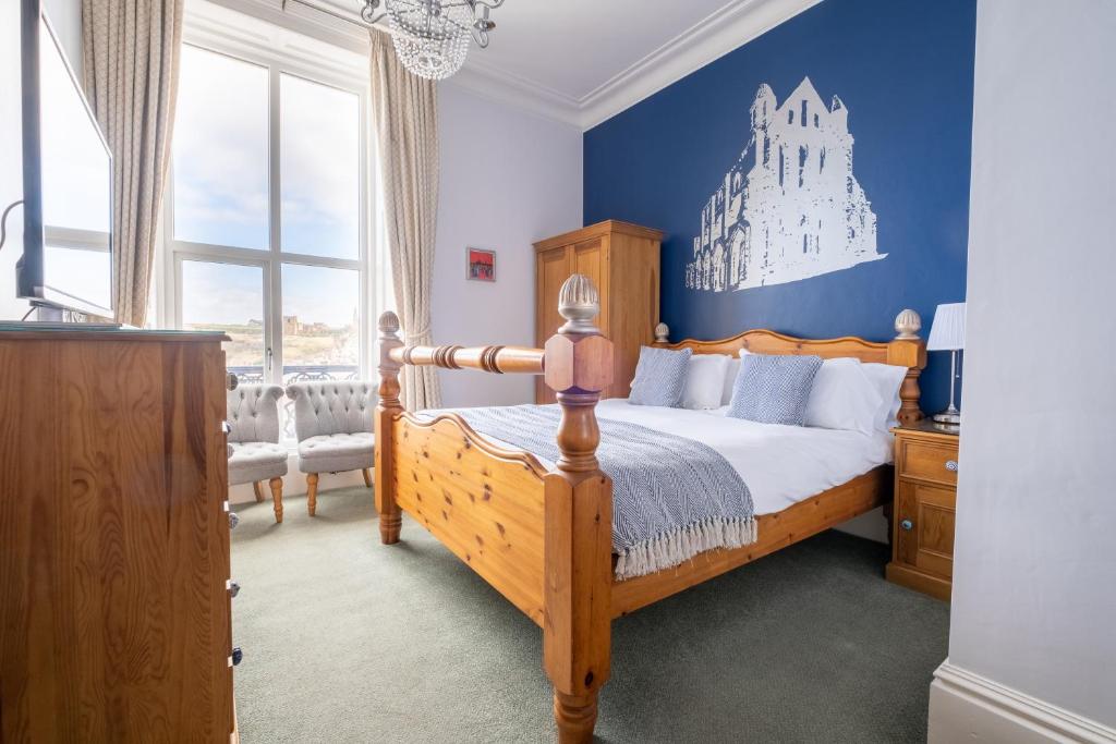 惠特比Number 7 Guest House的一间卧室设有一张木床和蓝色的墙壁