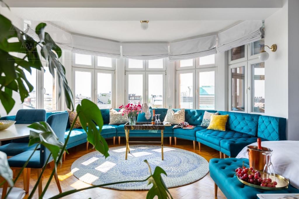 克拉科夫Feniks Fragola Apartments的客厅配有蓝色的沙发和桌子