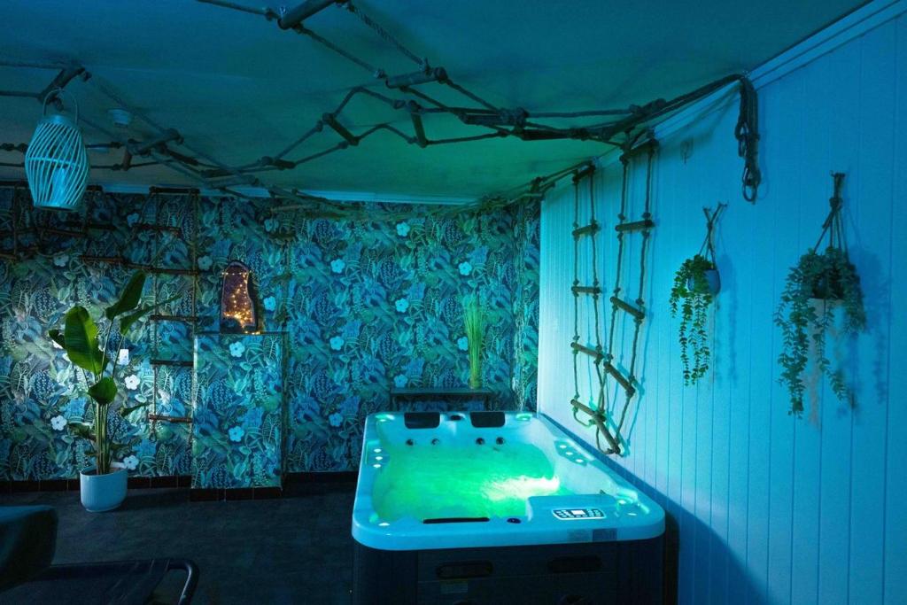 FloreffeCasawellness améthyste ou jaspe océan avec jacuzzi intérieur的蓝色灯的客房内的浴缸