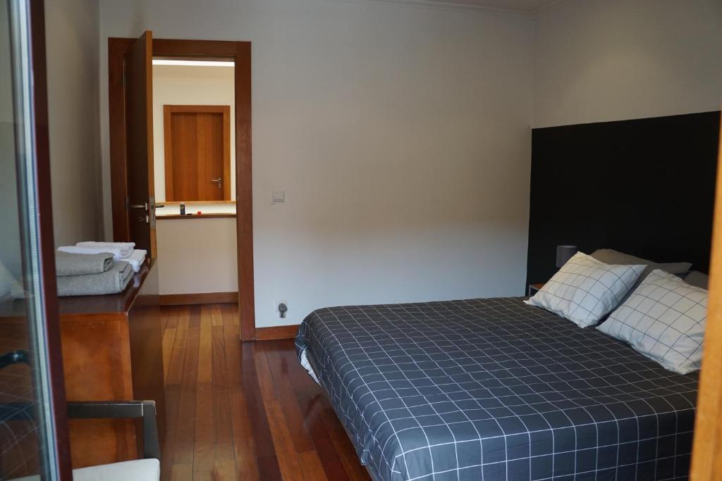 PerafitaMoradia, 4 quartos, a 200 metros da praia的一间卧室配有一张带蓝色格子毯子的床