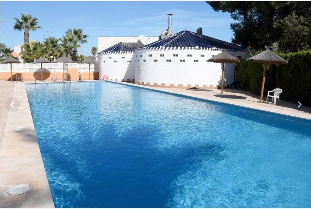 卡塔赫纳VILLA ARTEP Lujoso apartamento con piscina comunitaria的大楼前方的蓝色海水大型游泳池