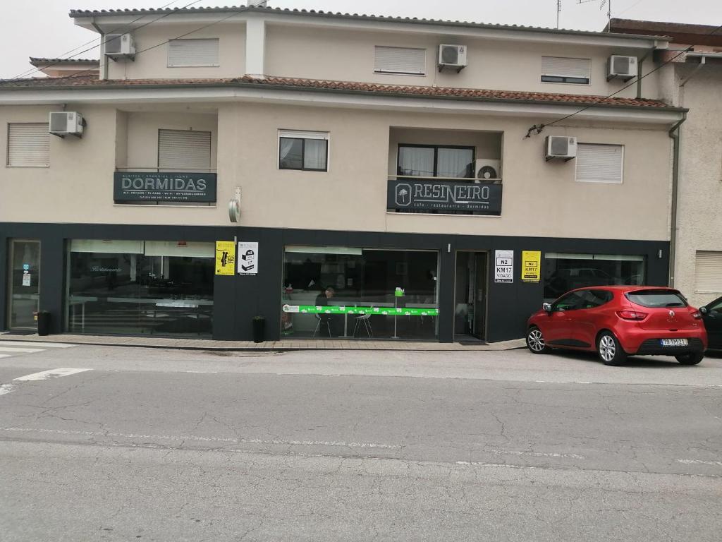 维达古Restaurante e Residencial O Resineiro的停在大楼前的红色汽车
