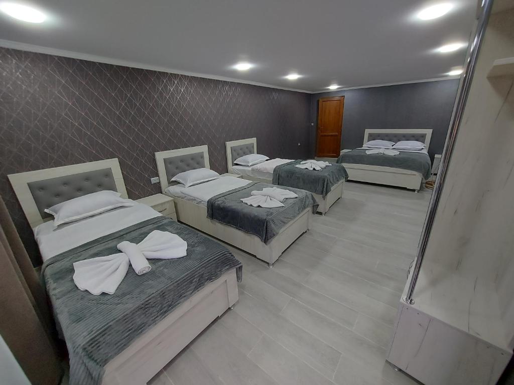 阿哈尔齐赫Hotel Rabat Castle的带三张床和镜子的客房