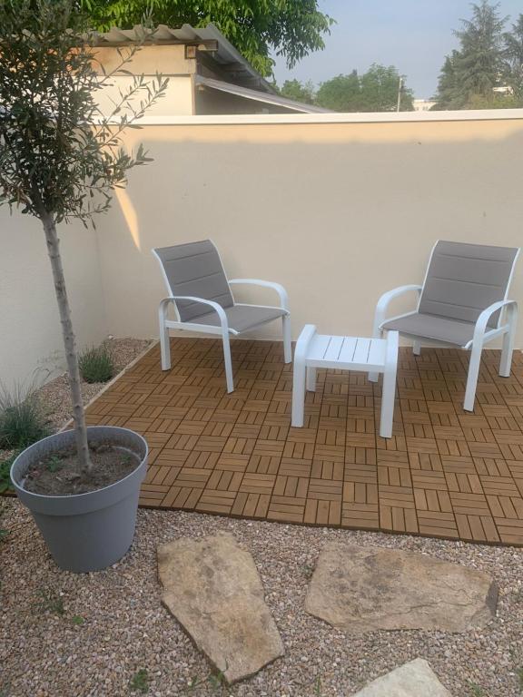 昂德雷济厄布泰翁villa bleu marine chic calme et jardin的庭院里设有两把椅子和一张长凳