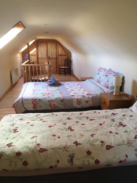 Kate’s Cottage的一间卧室配有两张带鲜花的床单