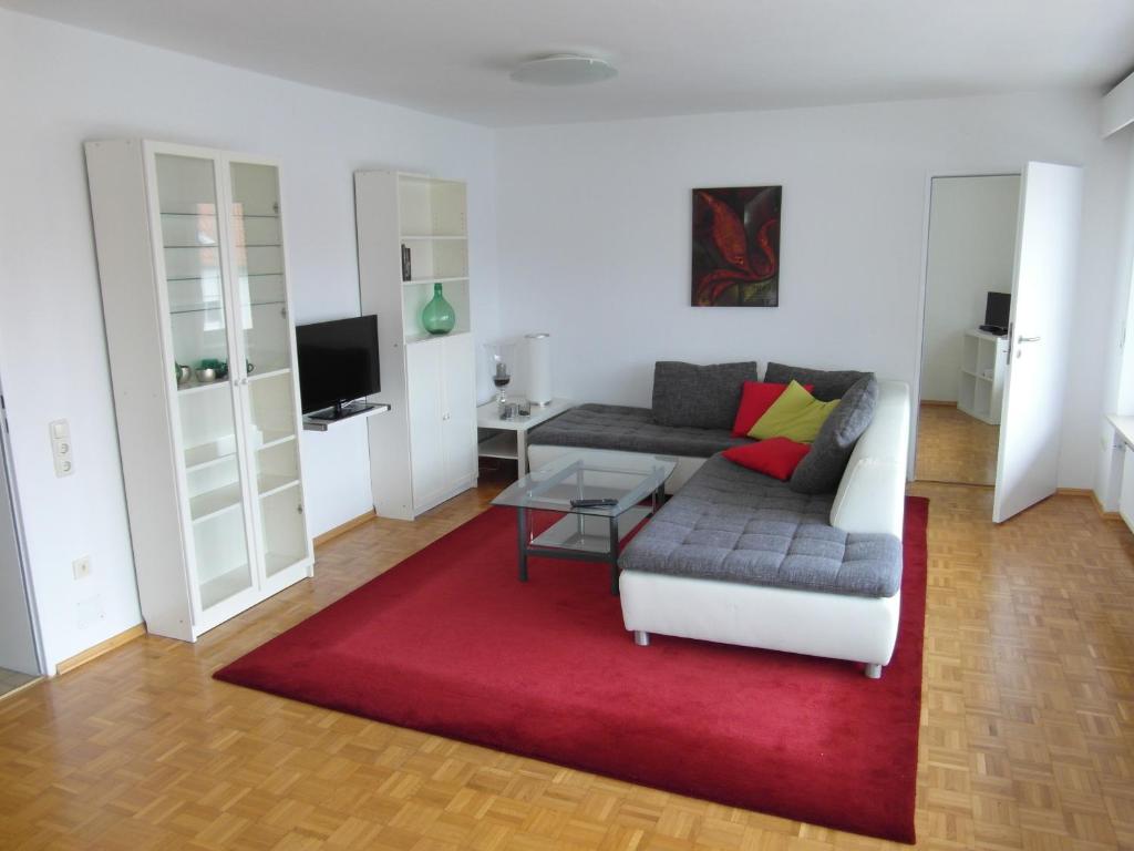 奥格斯堡奥古斯塔逃遁公寓的带沙发和红色地毯的客厅