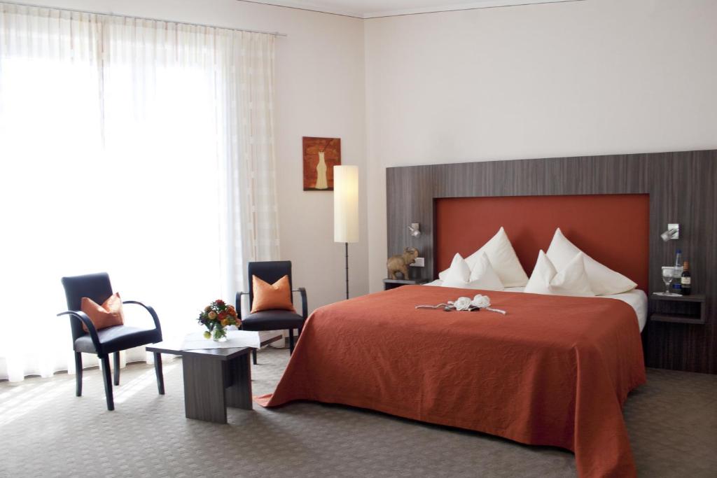 埃尔丁林奈酒店的酒店客房带一张大床和两张椅子