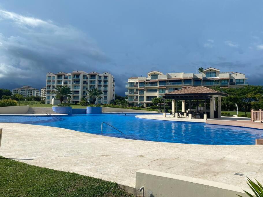 圣卡洛斯Lujoso y Familiar Apartamento de Playa y Golf en San Carlos Panamá的一个带凉亭和大楼的大型游泳池