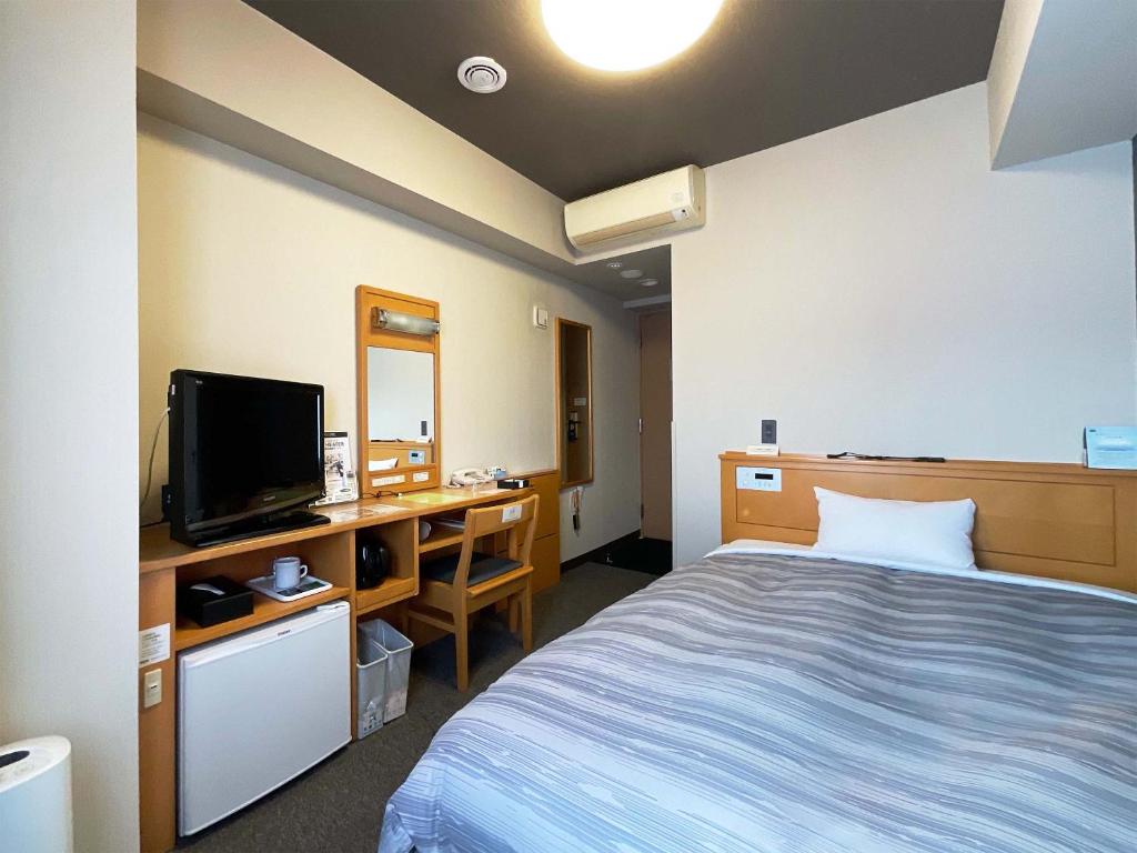 会津若松会津若松市茹特酒店的客房设有一张床、一张书桌和电视