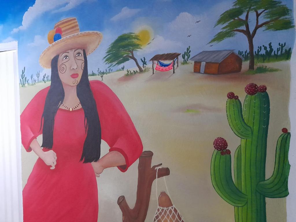 里奥阿查Casa Hostal Perla Roja的红裙和仙人掌中妇女画