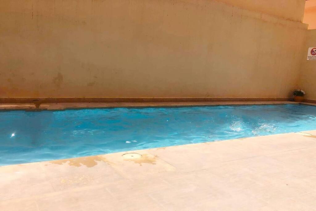 马拉喀什appartement dans résidence Marrakech avec piscine的室内的蓝色海水游泳池