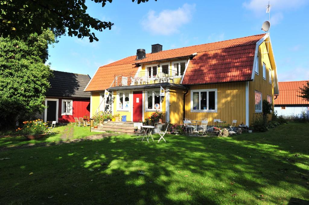 勒托普哈格白/农场瑞典旅游乡村民宿的一座黄色的房子,有红色的屋顶和院子