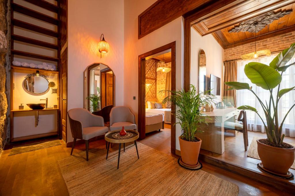 安塔利亚卡莱亦奇路线酒店 - 仅限成人（12岁以上）的客厅配有床和植物桌子