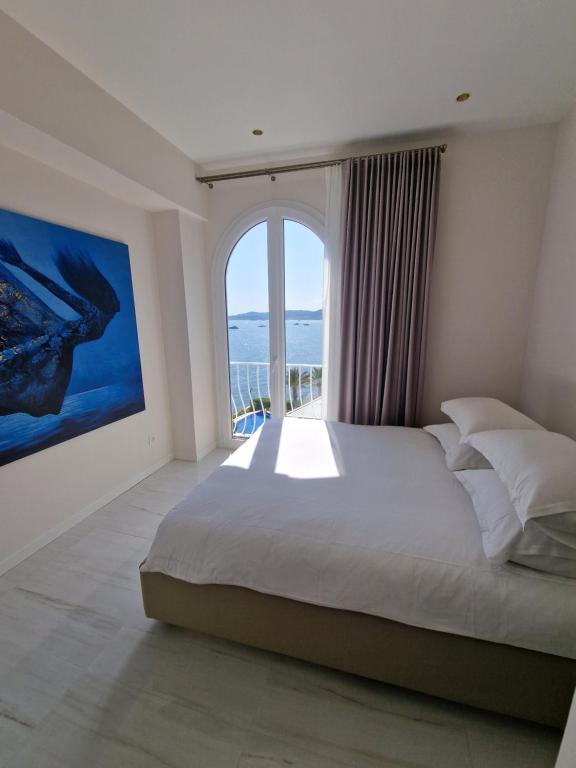 卡普戴尔Luxury 2-Bedroom Flat at the Seafront: Unforgettable Stay Near Monaco!的一间卧室设有一张大床和一个大窗户