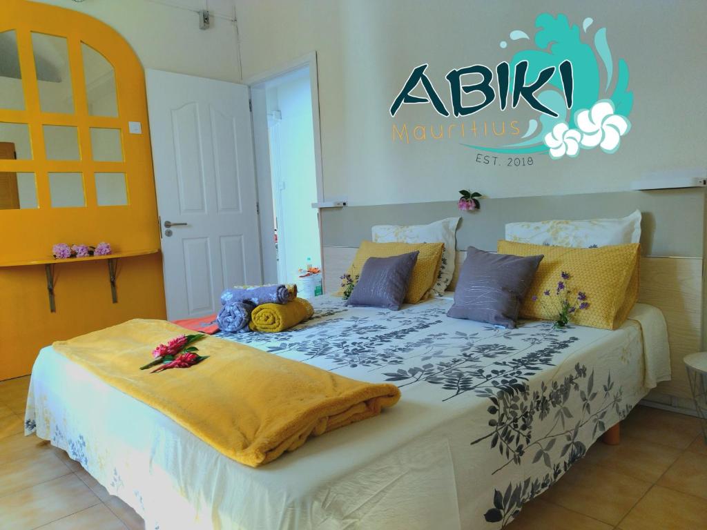 阿尔比恩Maya-Abiki Mauritius的一间卧室配有一张带鲜花的大床
