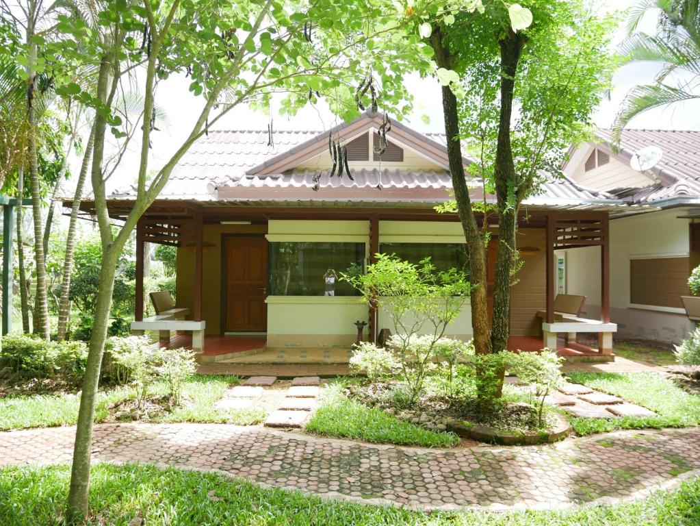 Ban Pa LauPala-U Garden Home (Time Pala-U)的庭院中带庭院和树木的房子