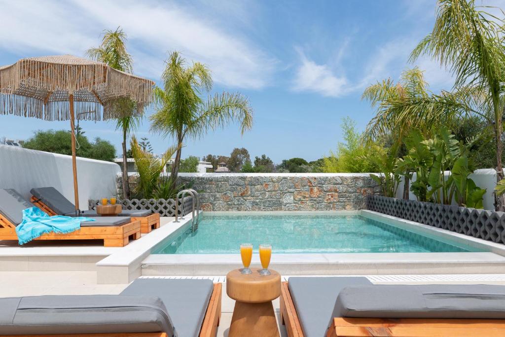 法里拉基Aqua Villa Faliraki的一个带庭院家具的游泳池和别墅