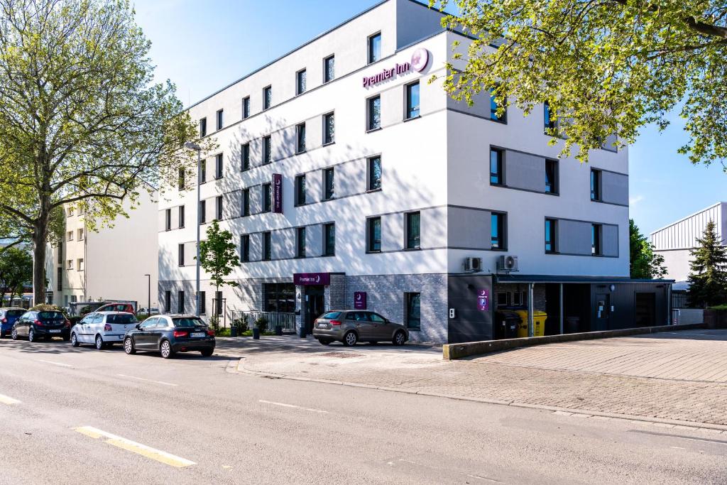 海德堡Premier Inn Heidelberg City Bahnstadt的白色的建筑,有汽车停在停车场