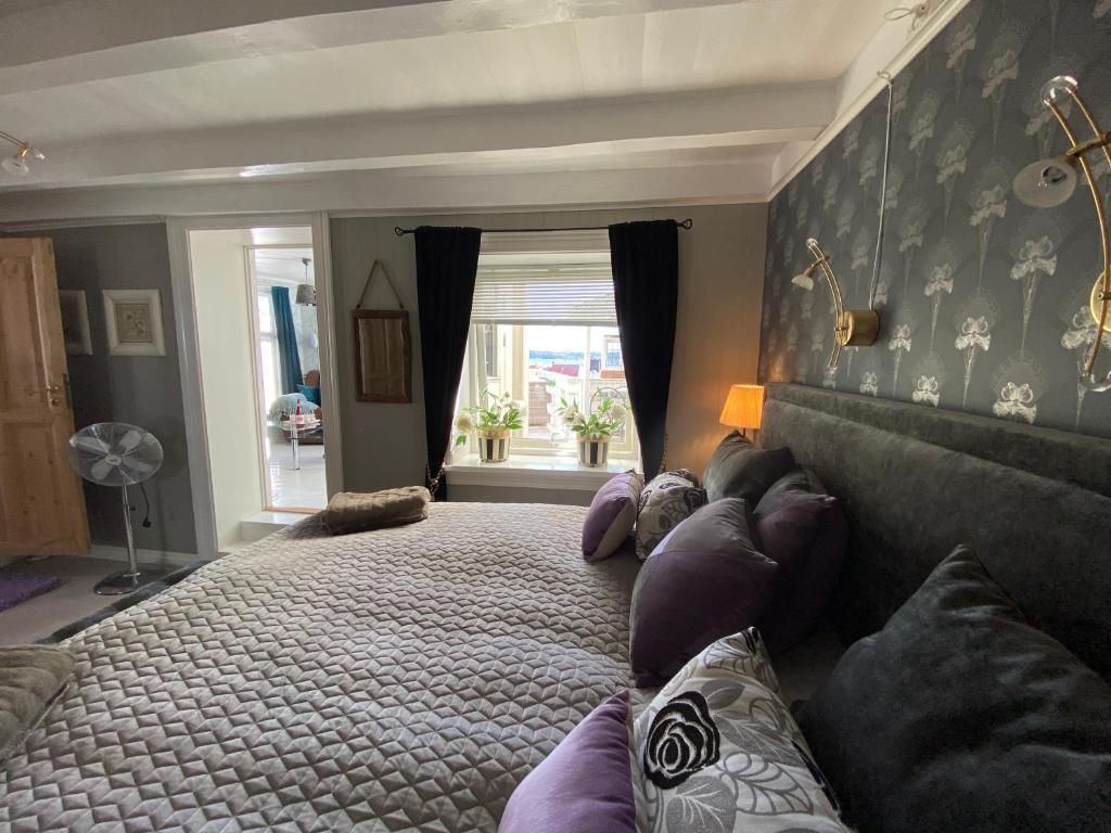 克拉格勒Monas sommerresidens midt i hjertet av Kragerø的一间卧室设有一张大床和一个窗户。