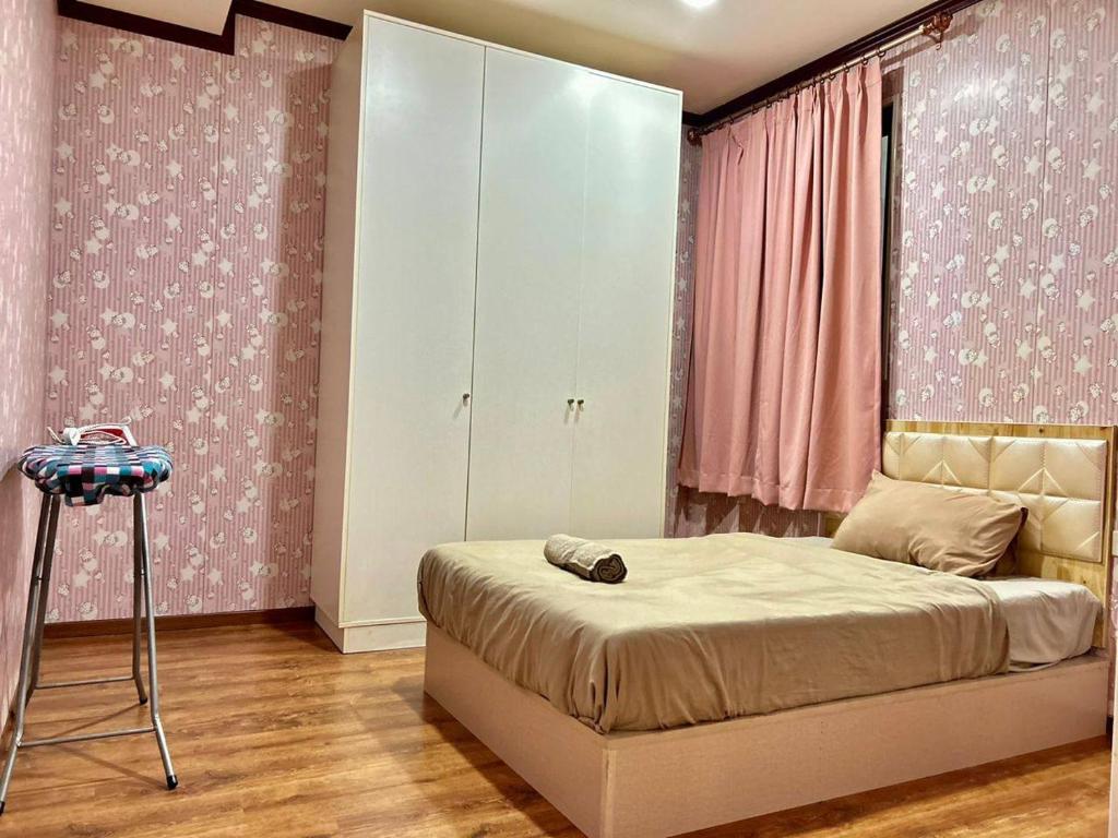 Kampong TabuanJeff and Ricky Homestay 39 @ Vivacity (Huge Unit)的一间卧室配有一张床和一个带粉红色墙壁的梳妆台。