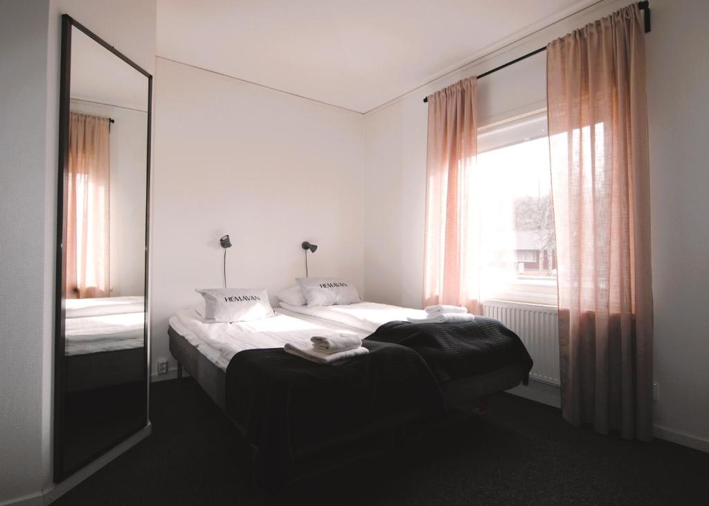 赫马万山区中心STF赫玛万斯酒店的一间卧室配有一张床、镜子和窗户