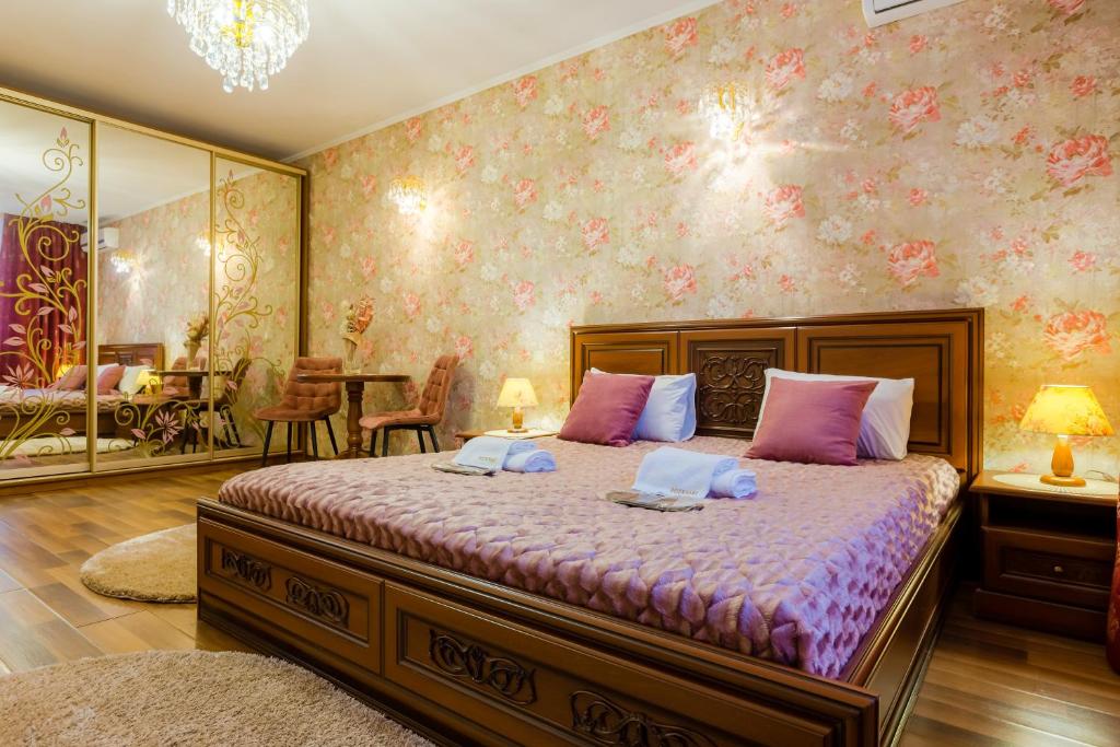 基辅Poznyakoff Aparthotel的卧室配有一张带粉红色墙壁的大床
