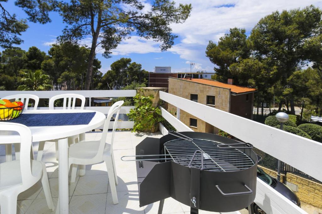 萨洛Codolar Planetcostadorada的阳台配有桌椅和烧烤架。