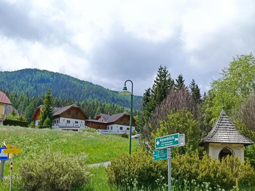 KrakauschattenFerienhaus Alpenblick的村前有房屋的街道标志