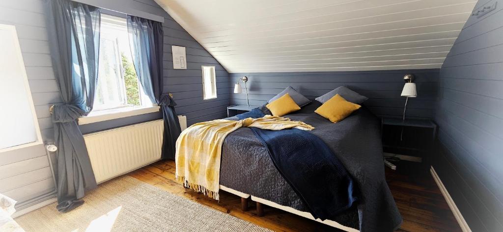 胡萨维克阿波尔旅馆的蓝色卧室配有带黄色枕头的床
