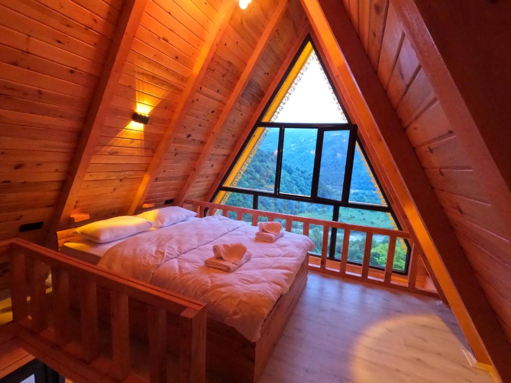 里泽Necran Bungalow اكواخ ايدر的小木屋内的卧室设有大窗户