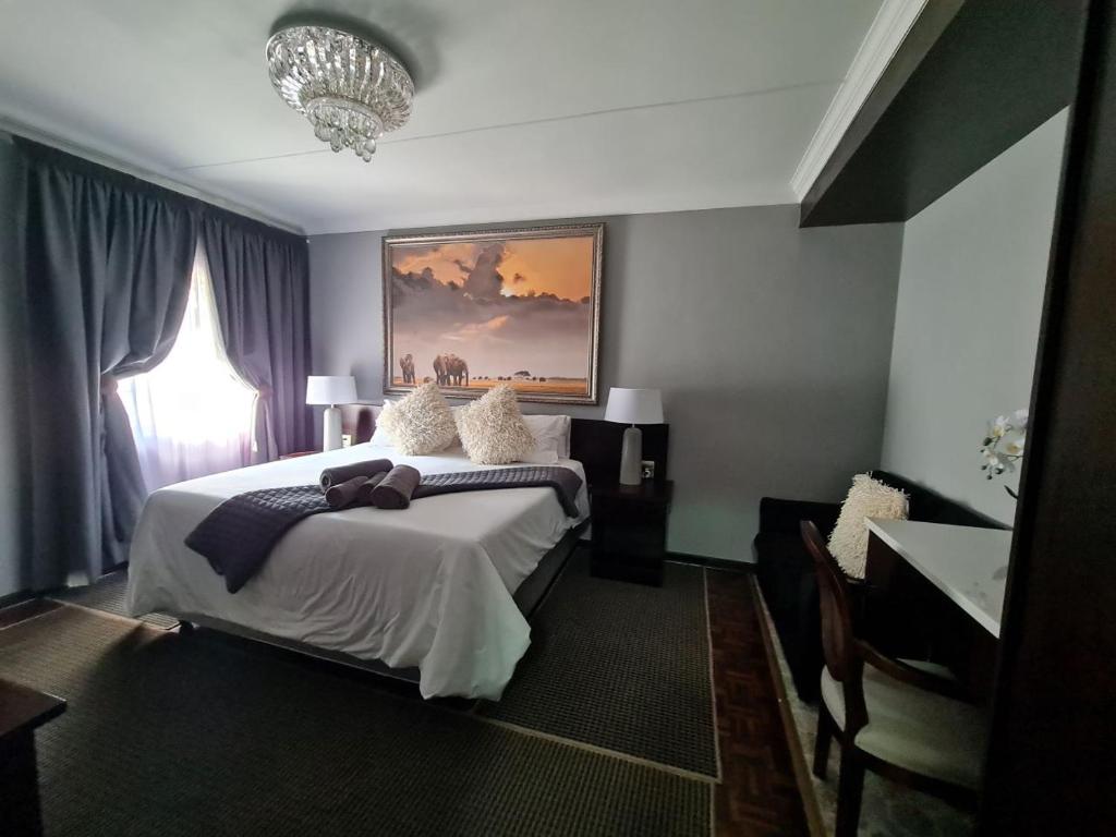 波罗瓜尼单里过夜旅馆的一间卧室配有一张大床和一个吊灯。