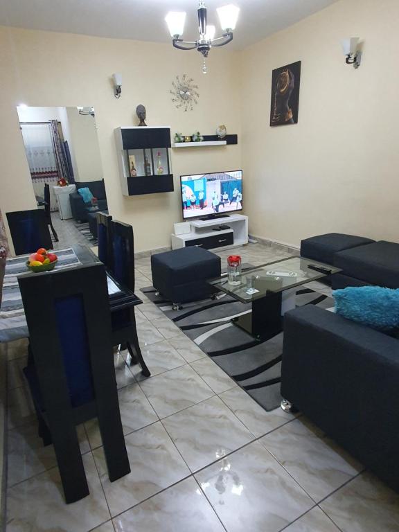杜阿拉Appartement Cosy & Chill的带沙发、桌子和电视的客厅