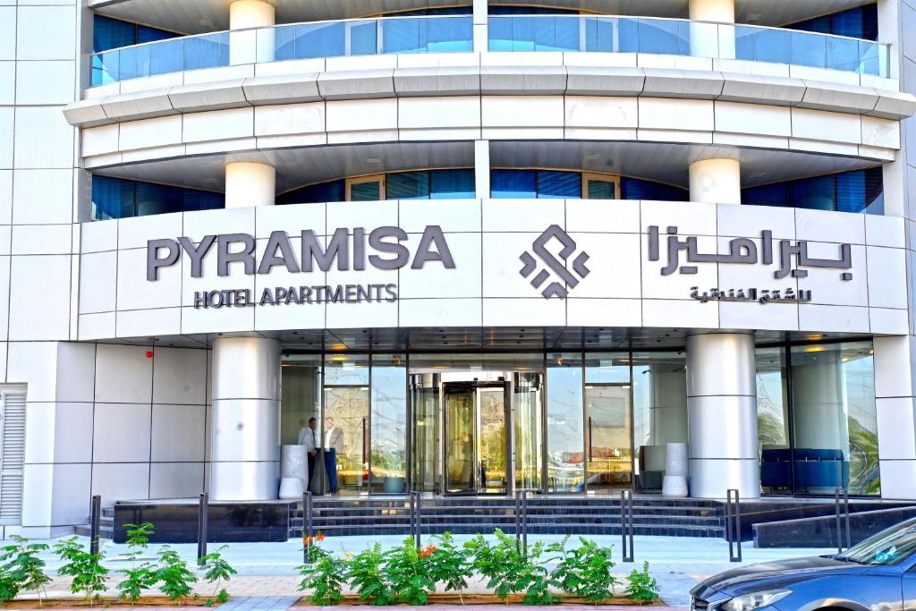 迪拜Pyramisa Hotel Apartments的一座建筑,上面标有阅读pyramasas酒店公寓的标志