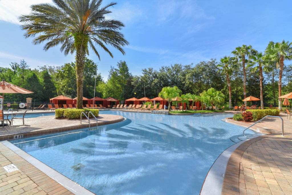 达文波特Near Disney w/ pool-3BR/2BA-Spacious & Cozy Condo的棕榈树和遮阳伞度假村的游泳池