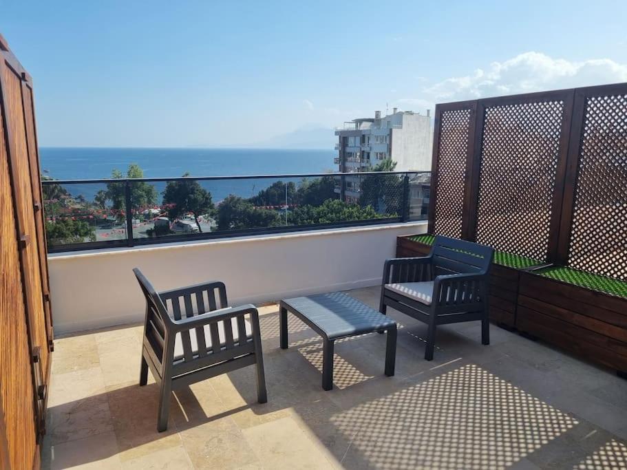 安塔利亚Royal Homes 502的俯瞰大海的阳台设有两把椅子和一张长凳