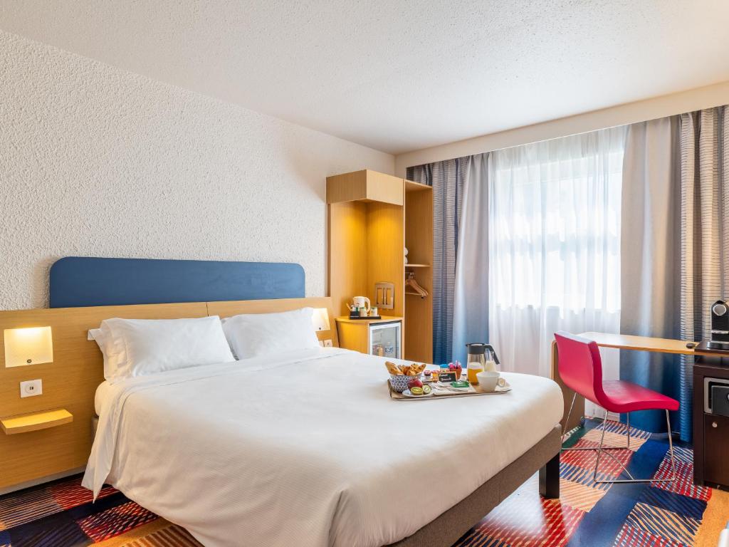 达迪利B&B HOTEL Lyon Nord 4 étoiles的一间酒店客房,配有一张床铺,上面放着一个食物托盘