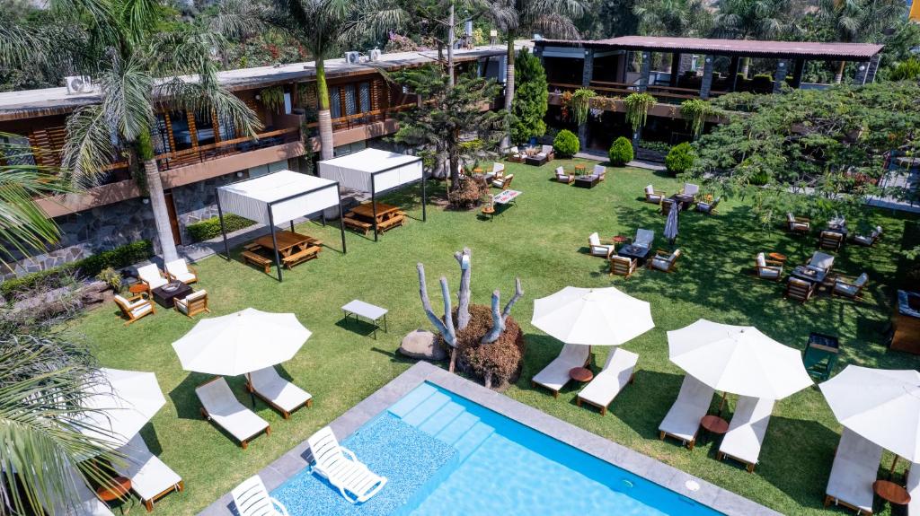 谢内吉亚区Hotel Campo & Leña的享有带遮阳伞的游泳池和度假村的顶部景致
