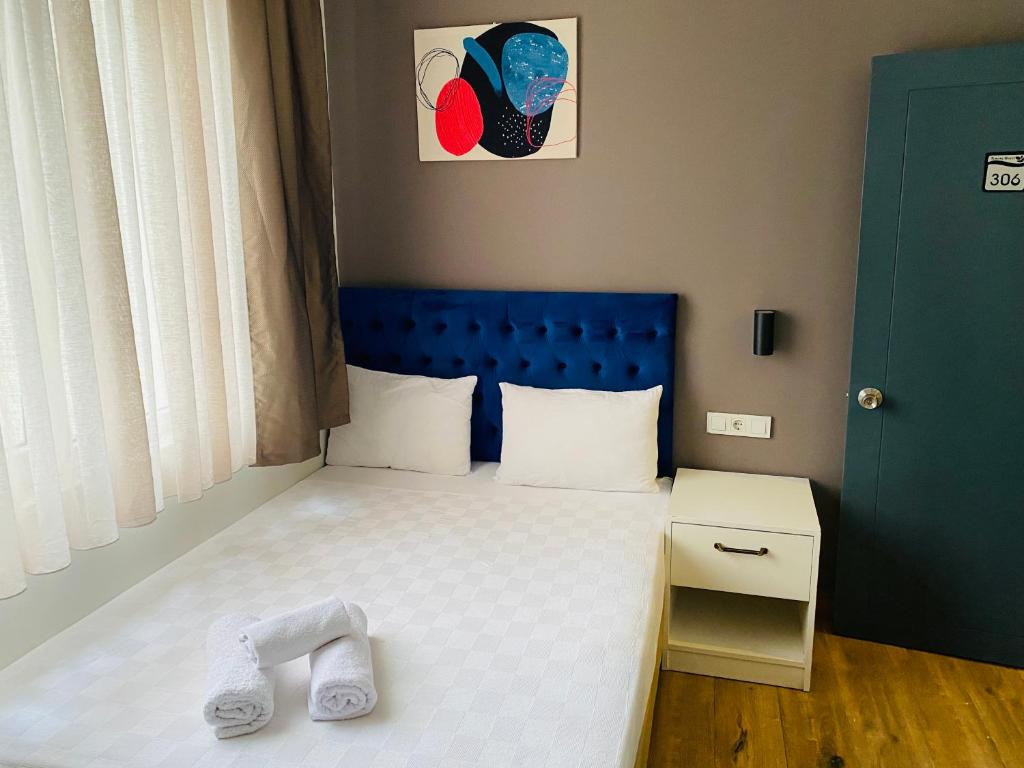安塔利亚Turunç Hotel ANTALYA的小卧室配有一张蓝色床头板的床