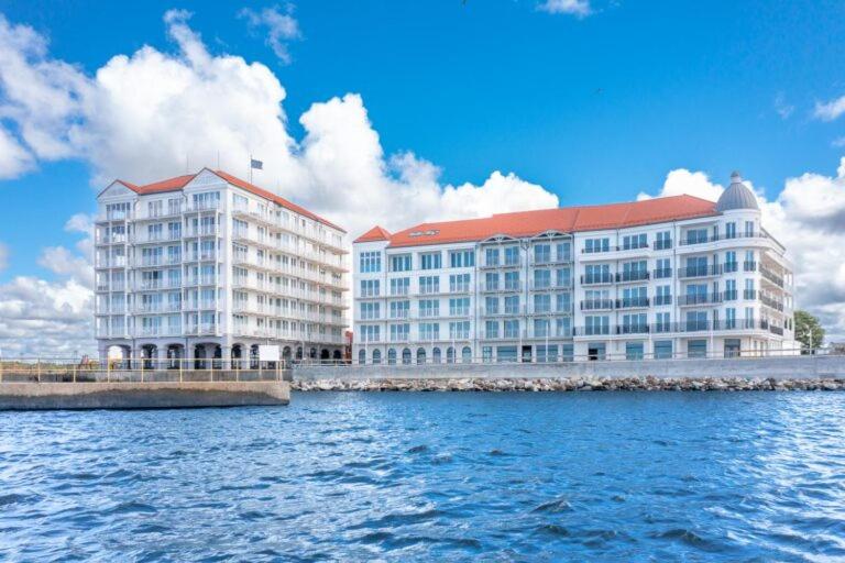 达洛科Marina Royale Darłowo - Apartamenty Ultra Mar nad morzem的两座白色大建筑,水面上设有红色屋顶