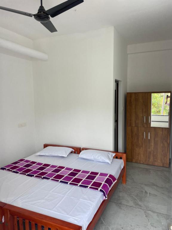 KotamangalamNew star homes的一间卧室配有一张铺有紫色和白色床单的床