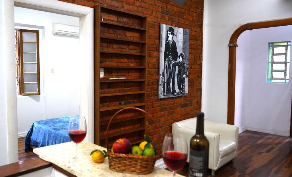 阿雷格里港Casinha的柜台,有两杯葡萄酒和一篮水果