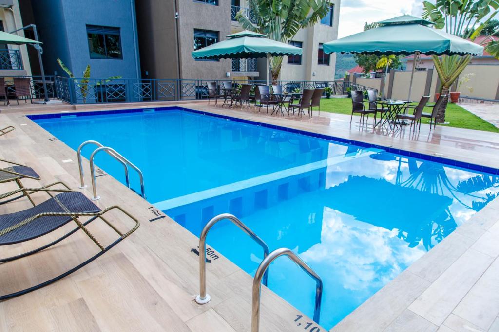 基加利Mountain View Hotel & Apartment的一个带椅子和遮阳伞的游泳池
