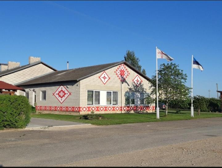 ObinitsaObinitsa Puhkemaja的前面有两面旗帜的房子